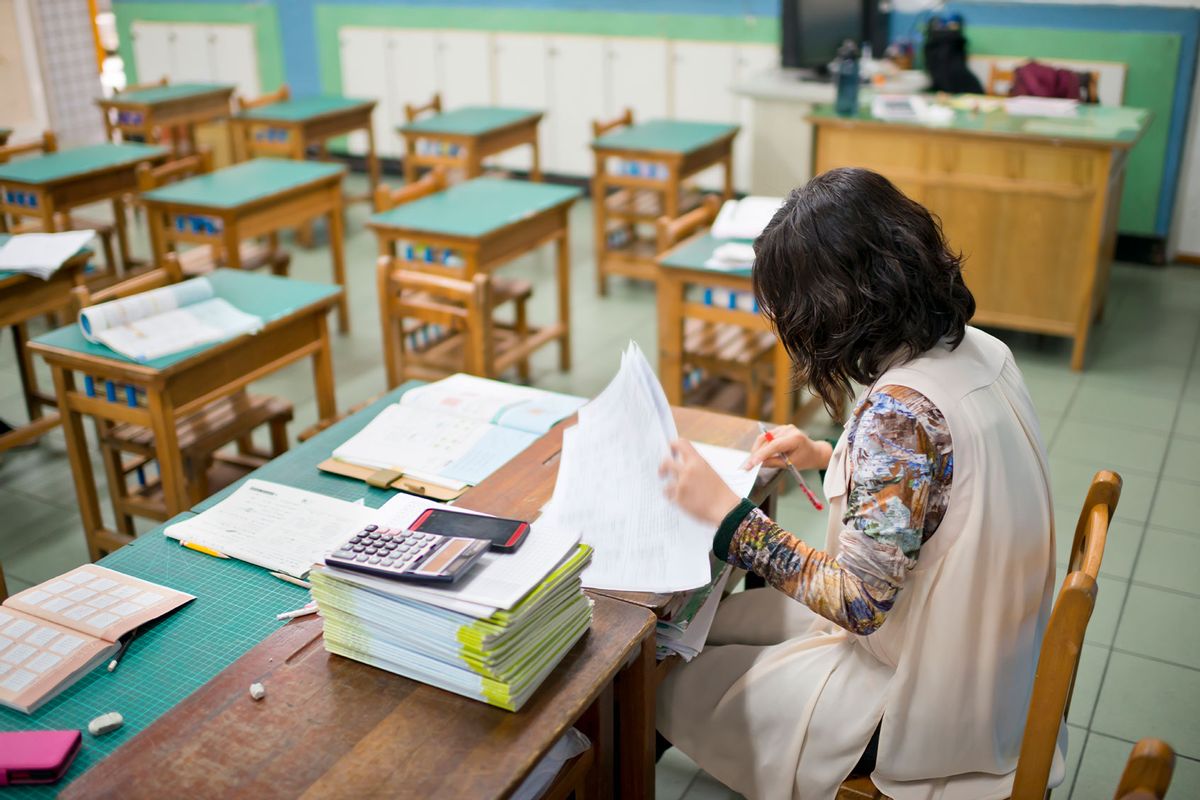 Teacher marking exam papers in classroom (Getty Images/Leren Lu)