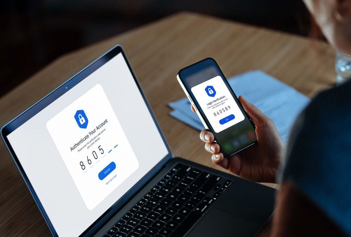 Woman using mobile device with Two-Factor Authentication (2FA) security while logging in securely to her laptop. (Getty Images/d3sign)