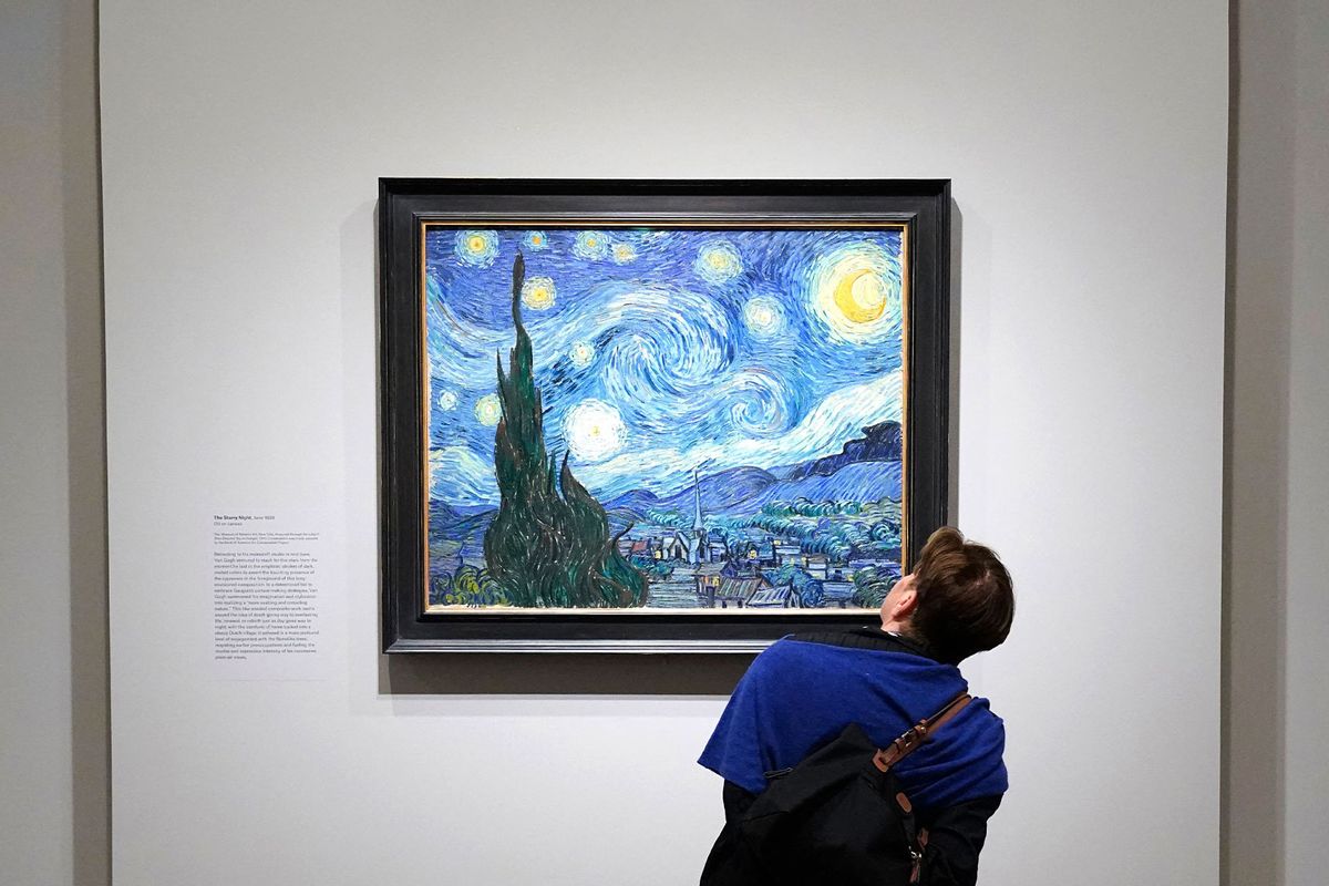 A person looks at Vincent van Gogh's "The Starry Night" during a press preview for Van Gogh's Cypresses at The Met Fifth Avenue in New York on May 15, 2023. (TIMOTHY A. CLARY/AFP via Getty Images)