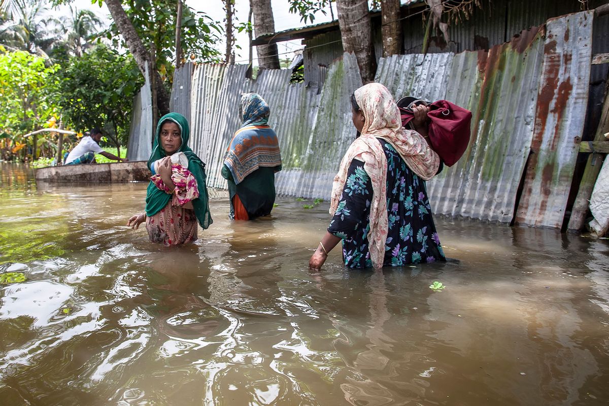 Women walk through waist-deep flood water in a village of Chaumuhni Municipality in Noakhali District of Chittagong Division in Noakhali, Chittagong, Bangladesh, on September 07, 2024. (Muhammad Amdad Hossain/NurPhoto via Getty Images)