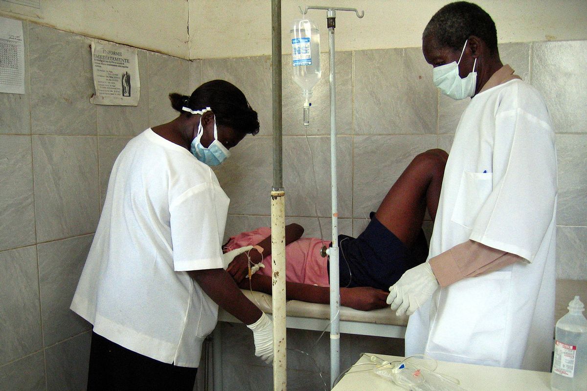 Angolan health workers treat, 05 April 2005, a 22-year-old woman, a new suspected case of the Marburg haemorrhagic fever in a clinic in Cacuaco township, outside Luanda, where the Ebola-like virus s killed at least 155 people. (FLORENCE PANOUSSIAN/AFP via Getty Images)