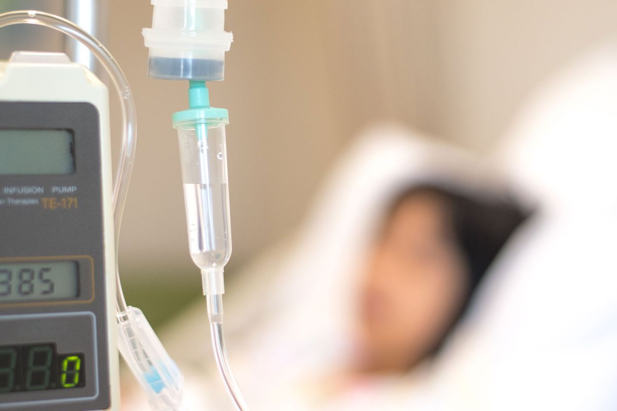 Child patient with IV line in hospital bed (Getty Images/Pornpak Khunatorn)