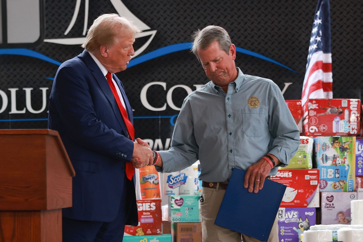 Republican presidential nominee, former U.S. President Donald Trump, shakes hands with Georgia Governor Brian Kemp as they visit the area while the people recover from Hurricane Helene on October 04, 2024 in Evans, Georgia. (Joe Raedle/Getty Images)