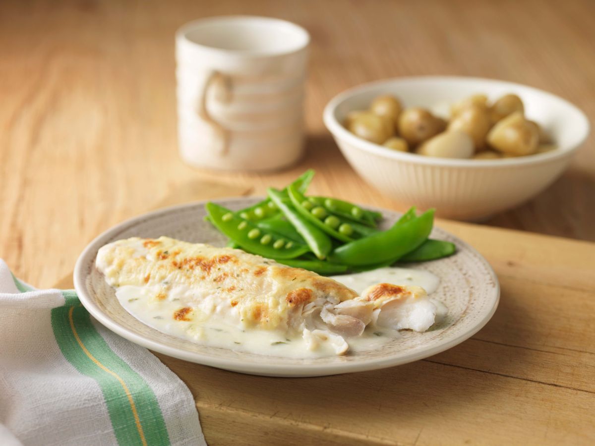 A plate of fish with peas and sauce. (Cultura RM Exclusive/Diana Miller via Getty Images)