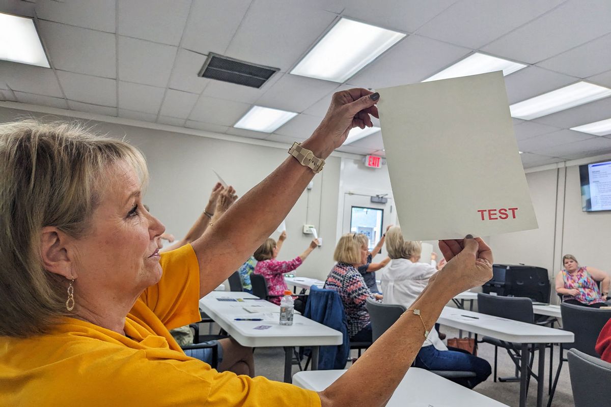 Lee County poll workers look for watermarks on voting paper during poll worker training in Leesburg, Georgia on October 2, 2024. (BECCA MILFELD/AFP via Getty Images)