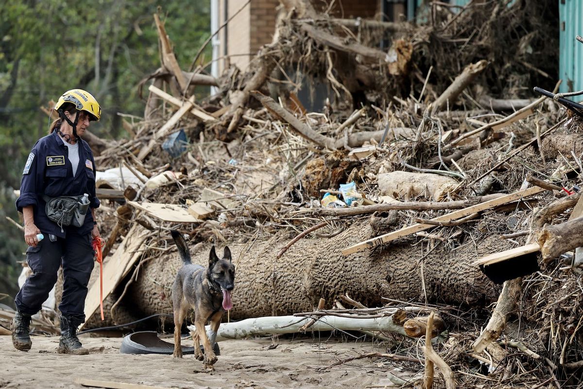 A member of the FEMA Urban Search and Rescue Task Force searches a flood-damaged property with a search canine in the aftermath of Hurricane Helene along the Swannanoa River on October 4, 2024 in Asheville, North Carolina. At least 215 people were killed in six states in the wake of the powerful hurricane which made landfall as a Category 4. President Joe Biden ordered the deployment of 1,000 active duty U.S. soldiers to assist with storm relief efforts in what is now the deadliest U.S. mainland hurricane since Hurricane Katrina. (Photo by Mario Tama/Getty Images)
