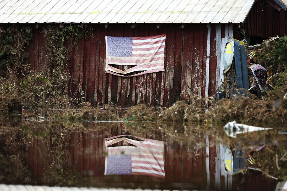An American flag is reflected in floodwaters remaining from Hurricane Helene on October 4, 2024 in Swannan, North Carolina. (Mario Tama/Getty Images)