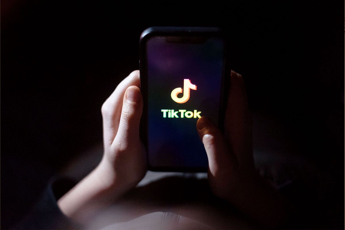 A 12-year-old boy looks at a smartphone screen displaying the TikTok logo on March 10, 2024 in Bath, England. (Matt Cardy/Getty Images)