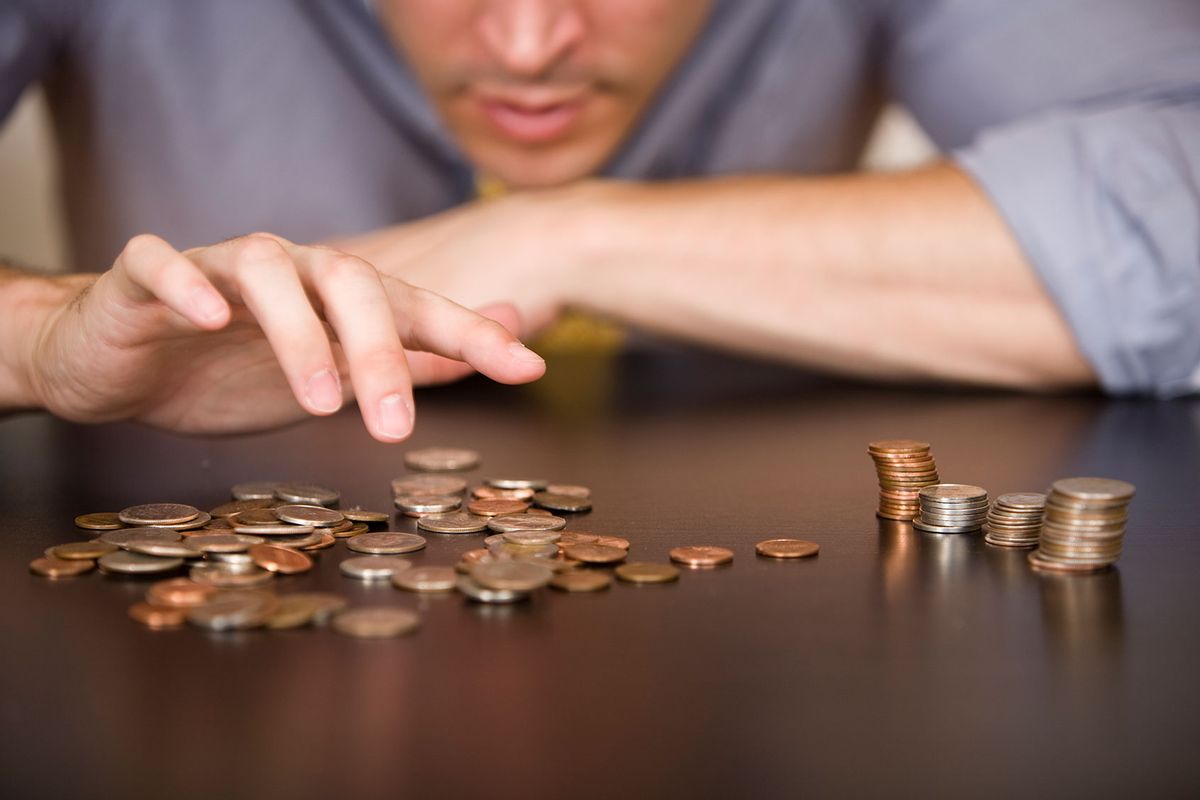 A man counts his coins on a tabletop.
 (Getty Images/MichaelDeLeon)