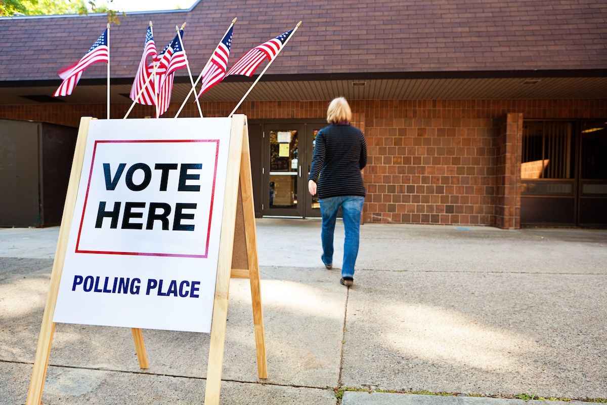 A woman entering a voting polling place. (YinYang / Getty Images)