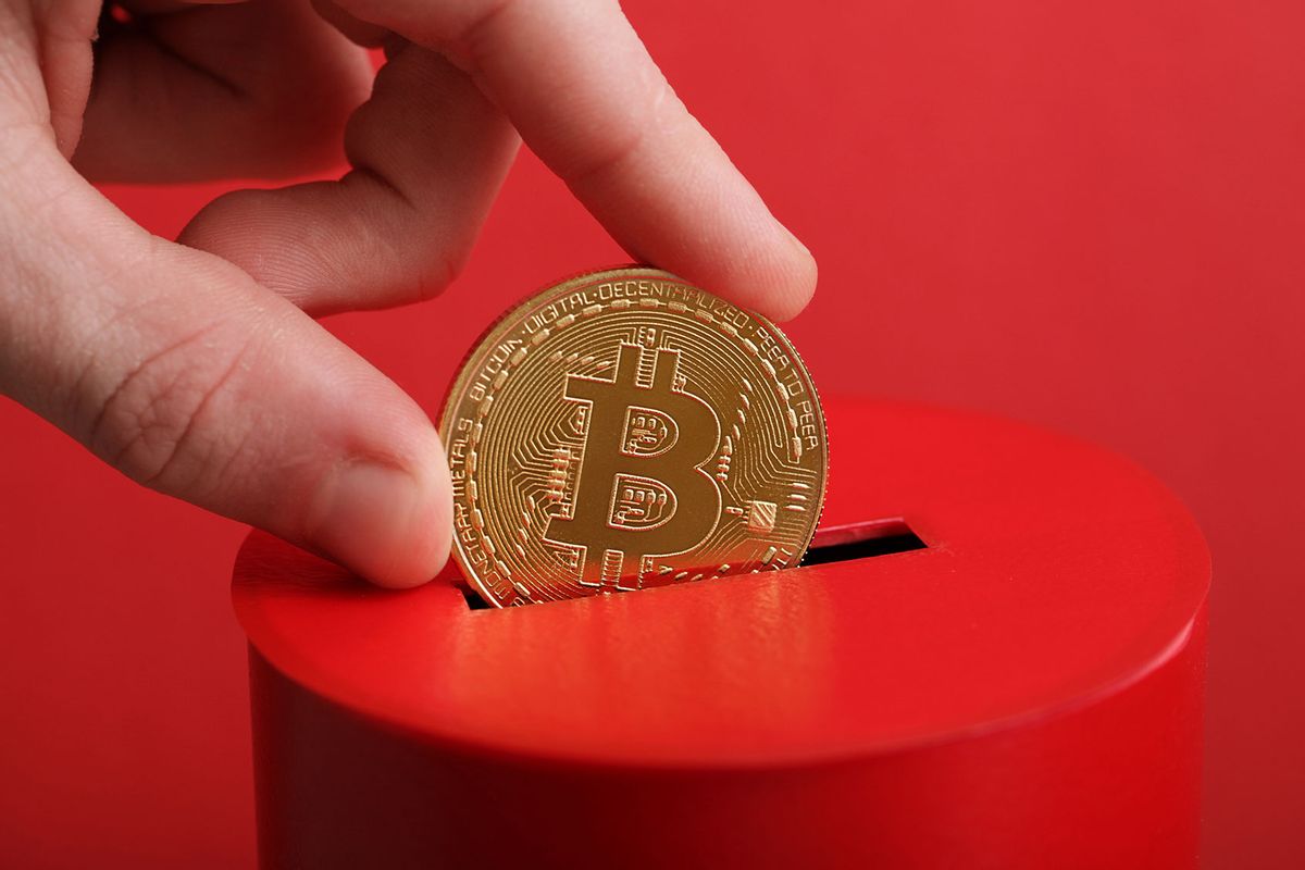 Putting bitcoin in a donation box (Getty Images/Liliya Filakhtova)