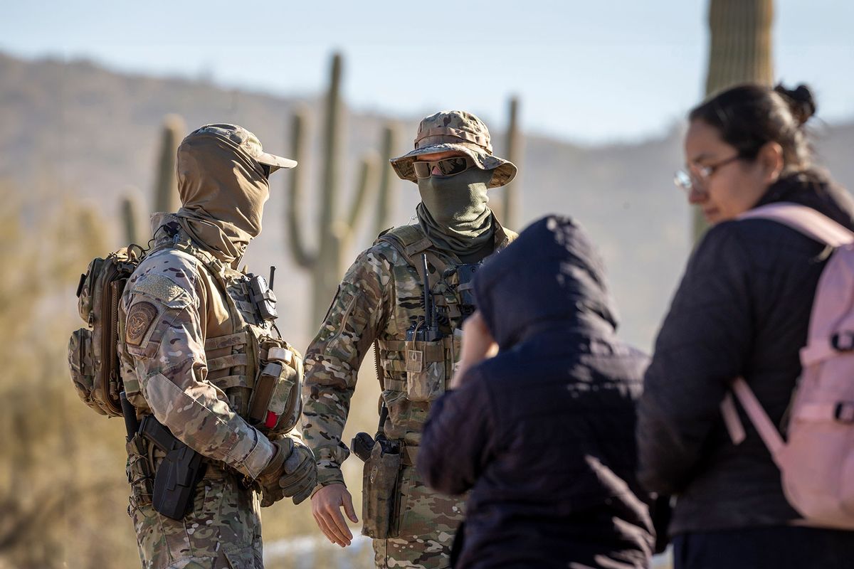 U.S. Border Patrol agents watch over immigrant families waiting to be transported from the U.S.-Mexico border on December 07, 2023 in Lukeville, Arizona. (John Moore/Getty Images)