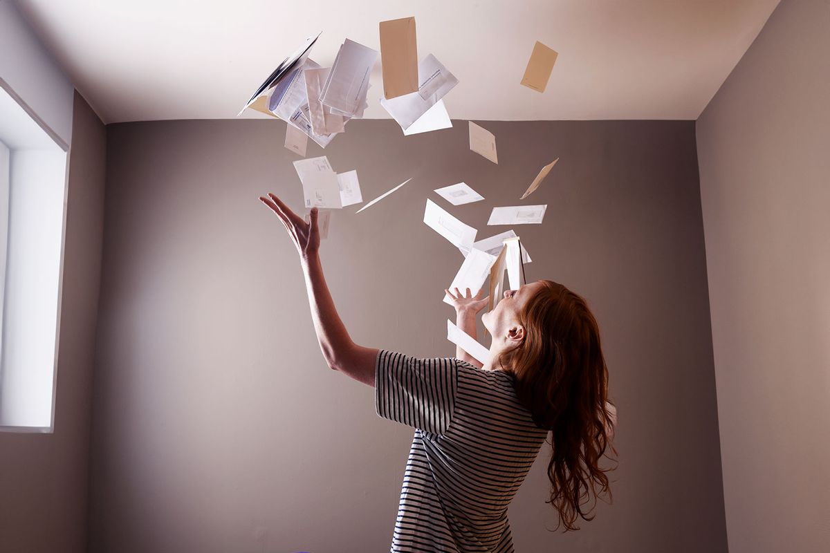 Woman throwing bills in the air (Getty Images/Photo_Concepts)