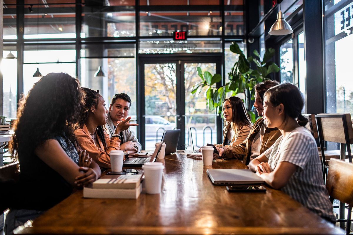 Young professionals collaborating in coffeeshop (Getty Images/MoMo Productions)