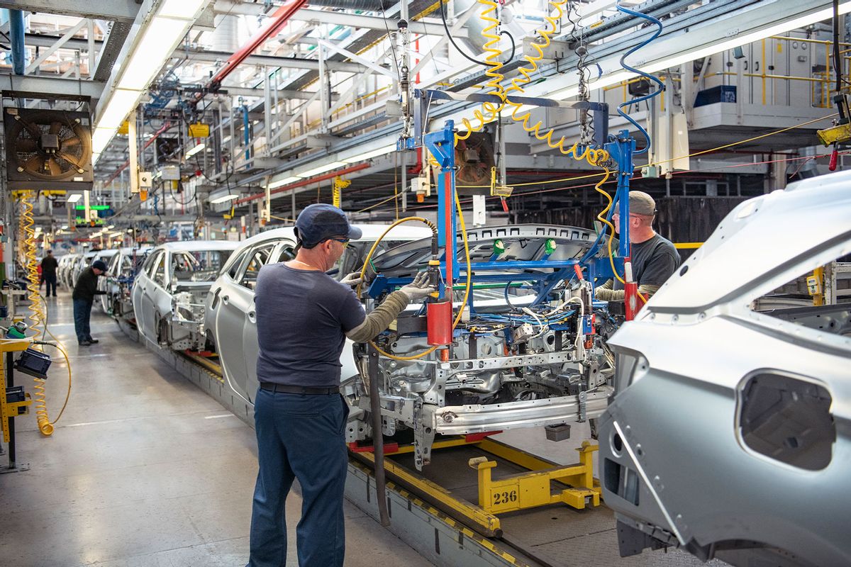 Car workers fitting bonnets to cars on production line in car factory (Getty Images/Monty Rakusen)