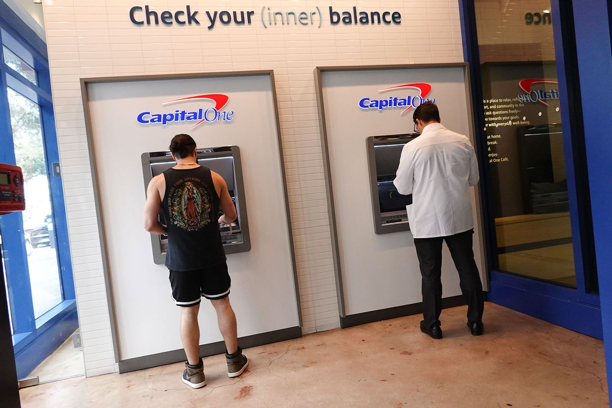 Customers make a transaction at a Capital One ATM on February 19, 2024, in Miami, Florida. (Joe Raedle/Getty Images)