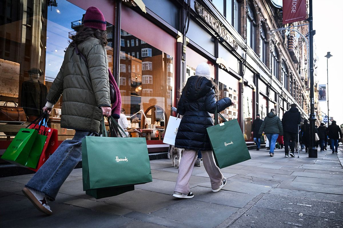 Pedestrians carry Harrods shoppins bags, in London, on December 22, 2024 on the last weekend before Christmas. (JUSTIN TALLIS/AFP via Getty Images)