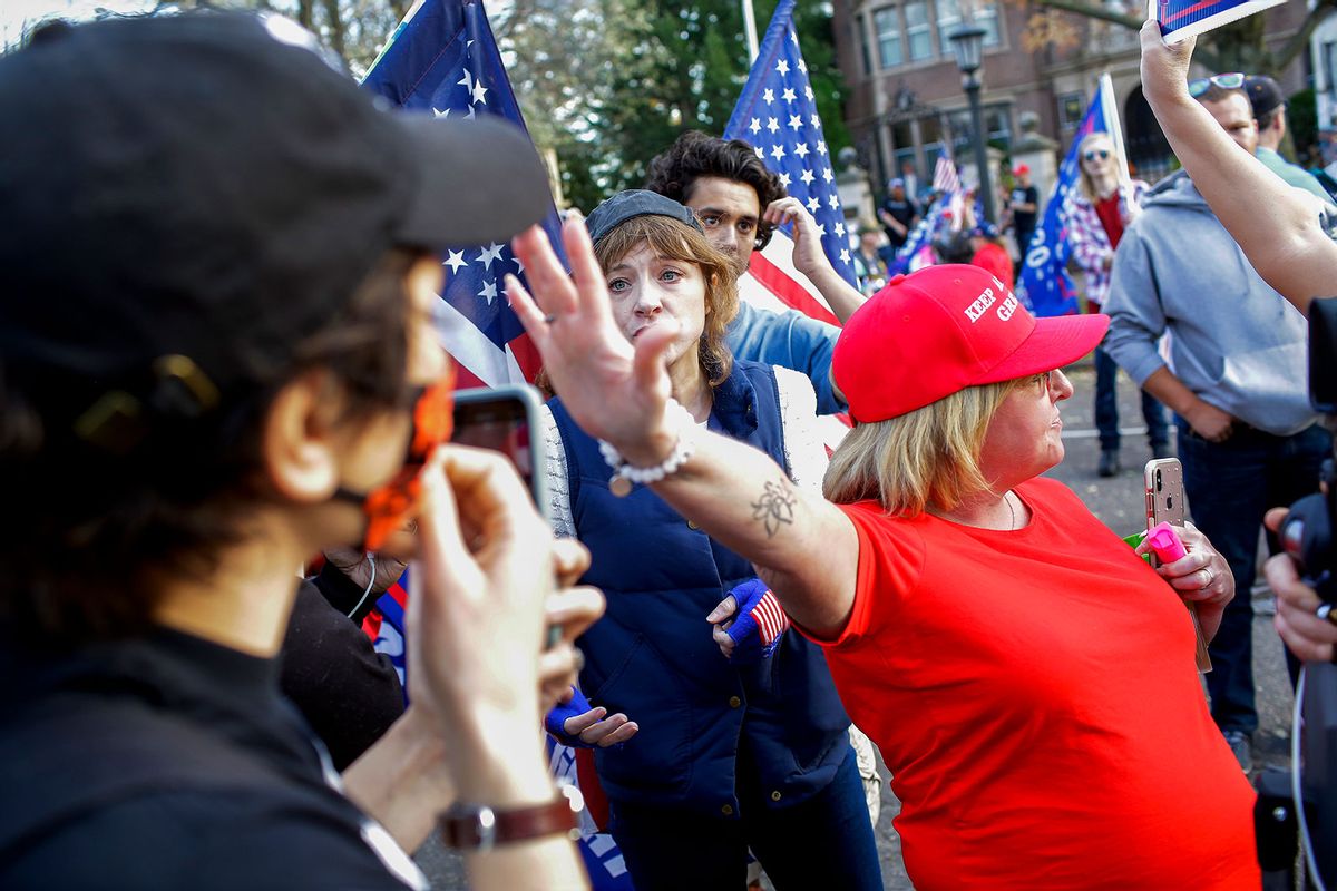 A President Donald Trump supporter (R) places her hand in the face of a counter protester during an argument after the election results after President-elect Joe Biden and Vice President-elect Kamala D. Harris were declared winners outside Minnesota Governor Tim Walz's mansion on November 7, 2020 in St. Paul, Minnesota. (Joshua Lott/The Washington Post via Getty Images)