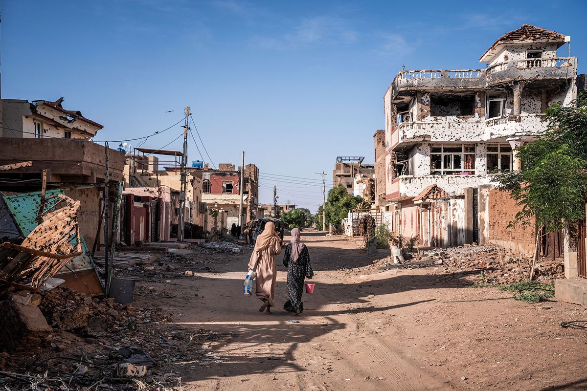 Women walk through a war-torn neighborhood in Omdurman on November 2, 2024. (AMAURY FALT-BROWN/AFP via Getty Images)