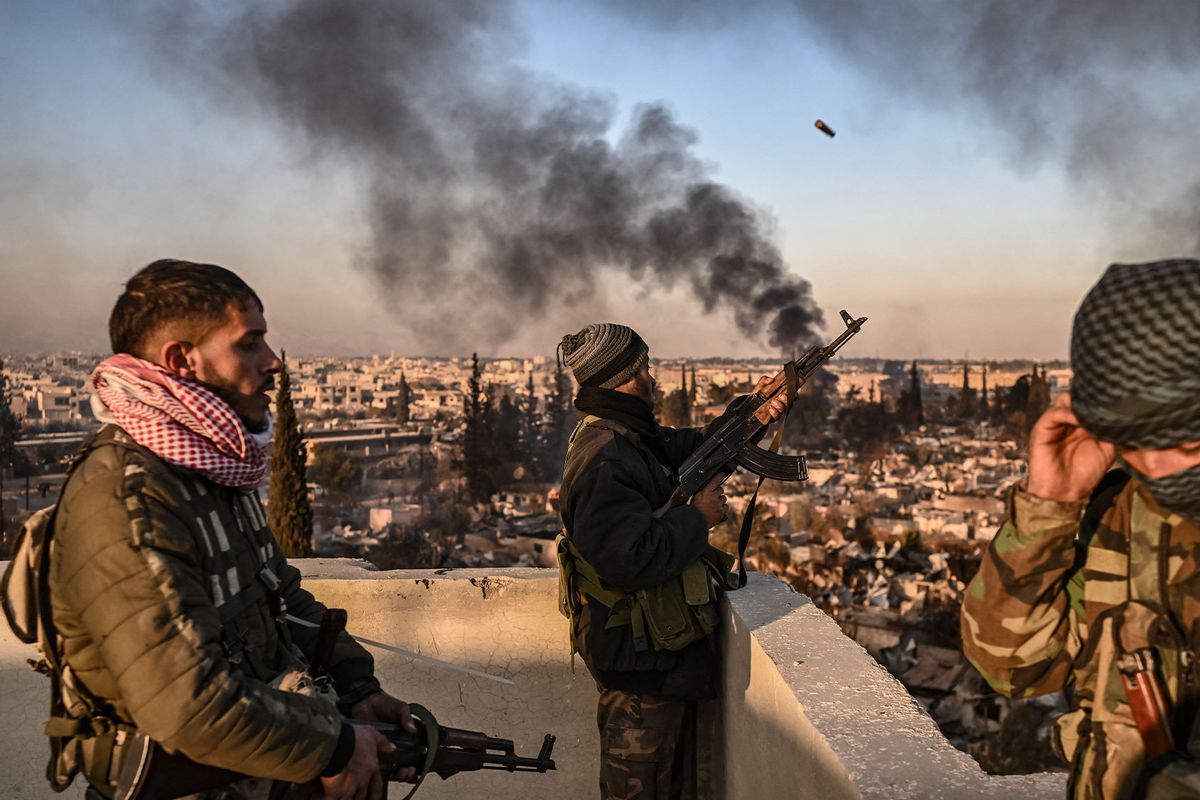 Gunmen stand on the roof of a building to push away looters from the Najha military housing complex in southeast Damascus on December 17, 2024. (ARIS MESSINIS/AFP via Getty Images)