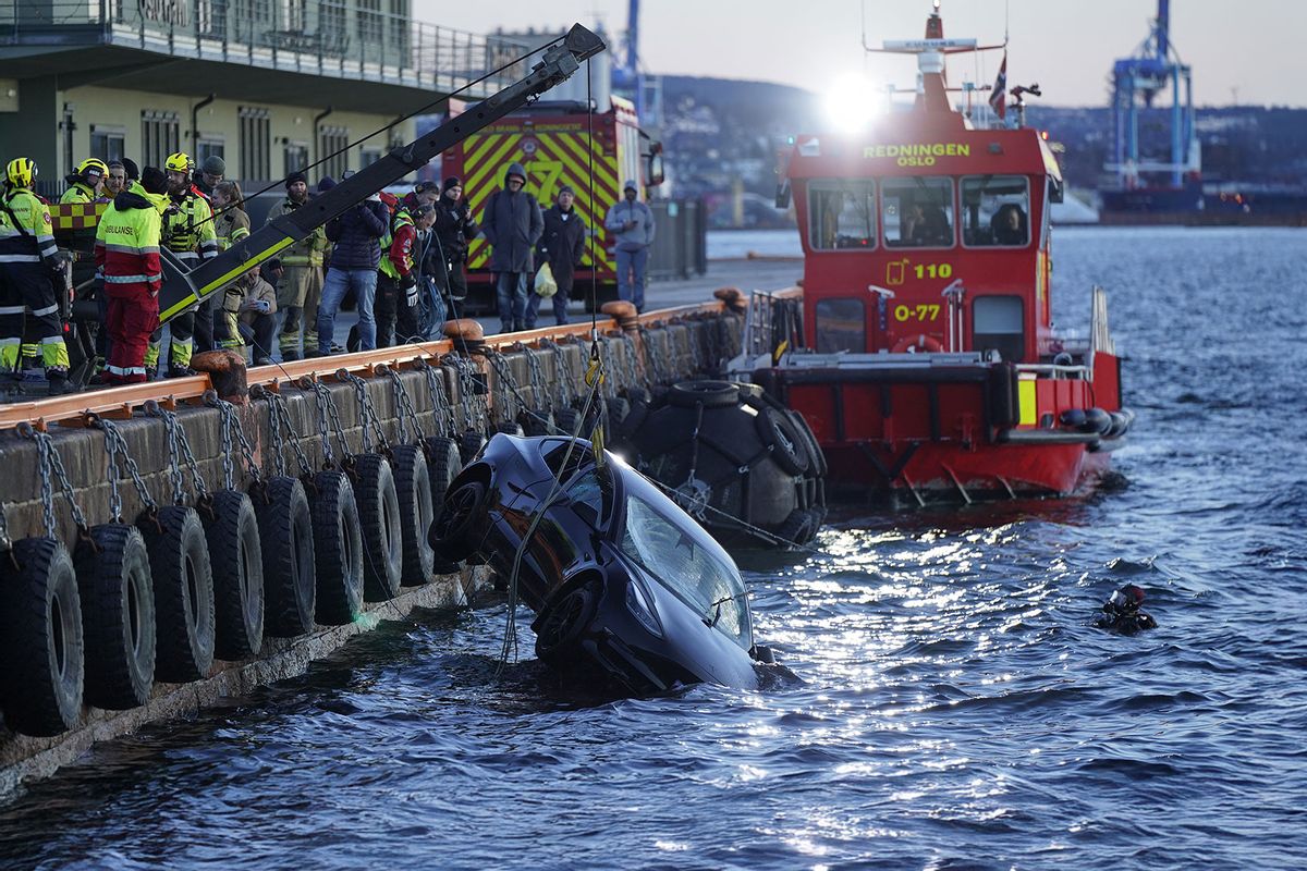 Rescue personnel retrieve a Tesla car from the water after driving out into the Oslofjord on February 1, 2024 in Oslo. (HAKON MOSVOLD LARSEN/NTB/AFP via Getty Images)