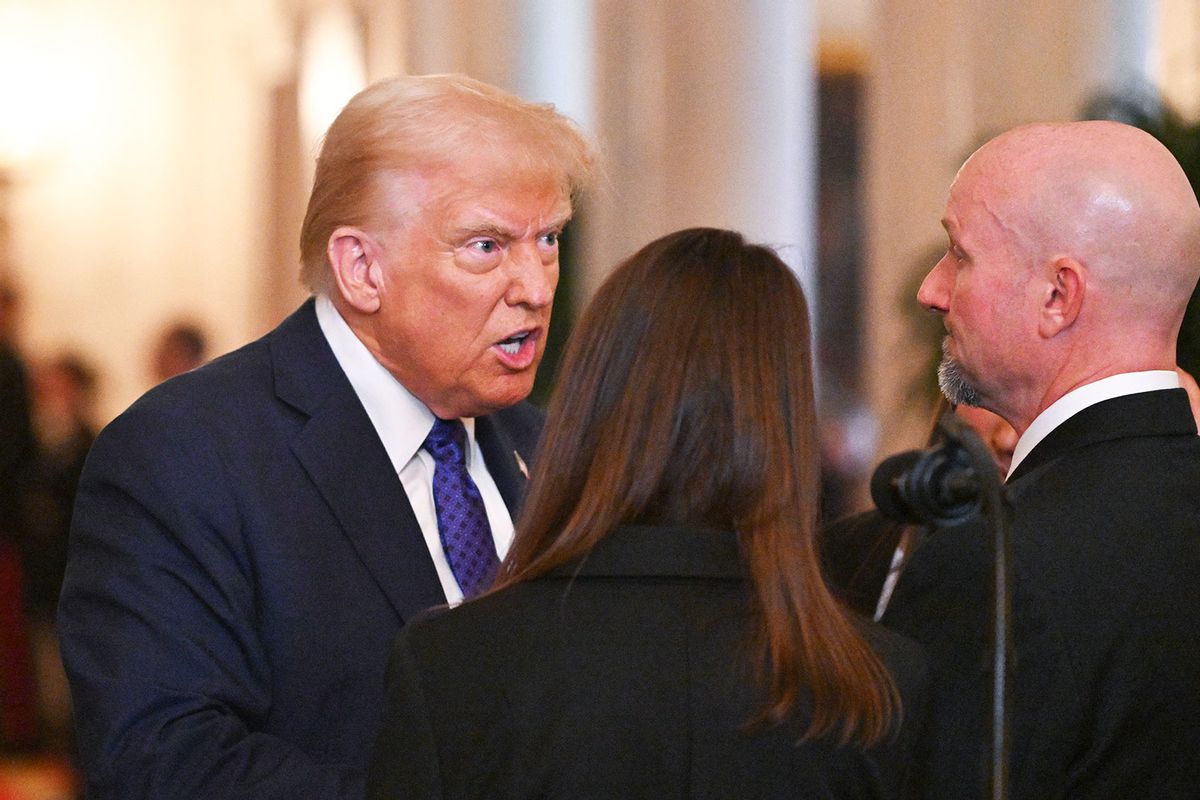 US President Donald Trump speaks with Allyson Phillips, mother of Laken Riley, and John Phillips, stepfather of Laken Riley, before signing the Laken Riley Act in the East Room of the White House in Washington, DC, January 29, 2025. (ROBERTO SCHMIDT/AFP via Getty Images)