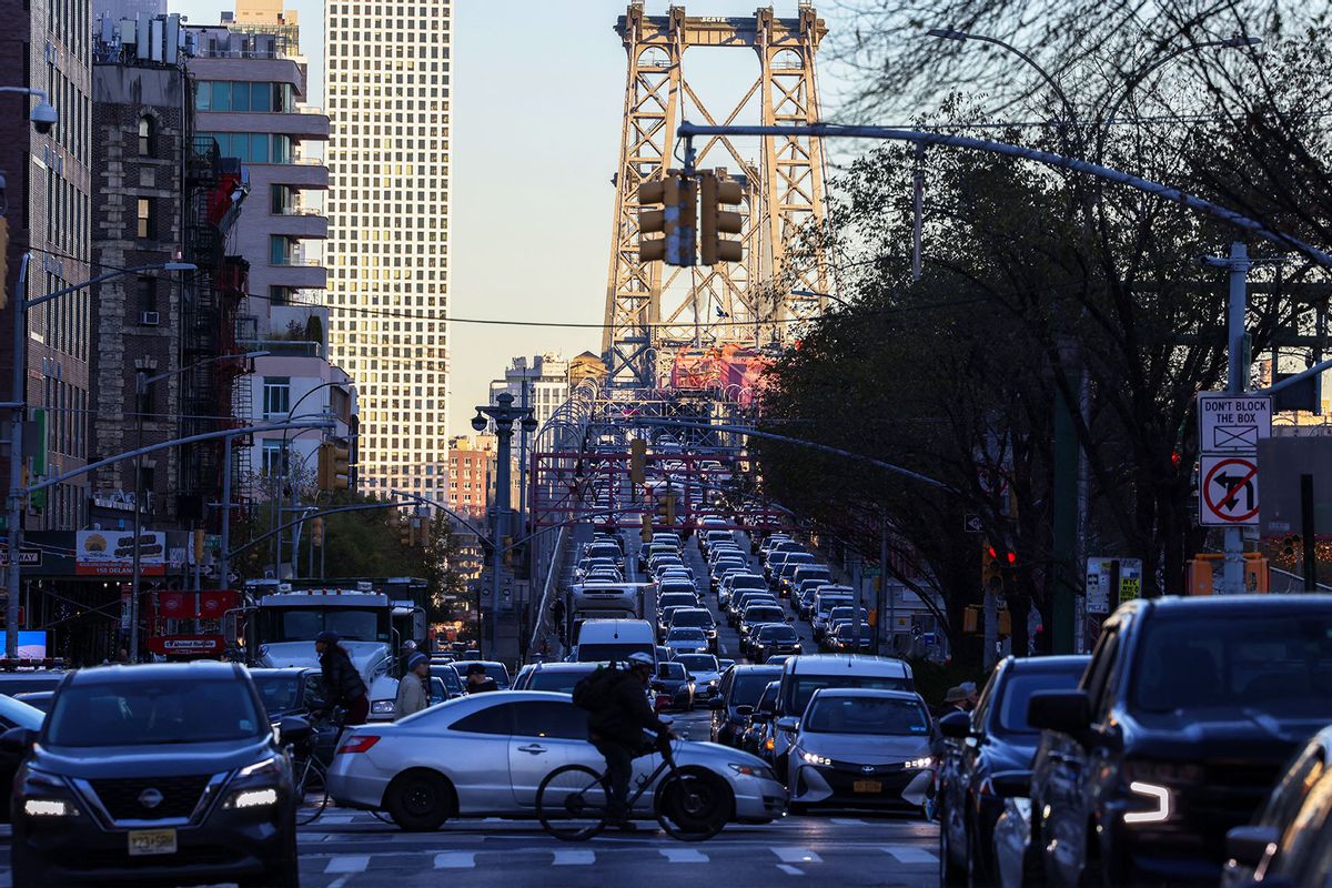 Pedestrians, cyclists and cars move along Delancey Street, with the Williamsburg Bridge in the background, in the Manhattan borough of New York on November 13, 2024. (CHARLY TRIBALLEAU/AFP via Getty Images)