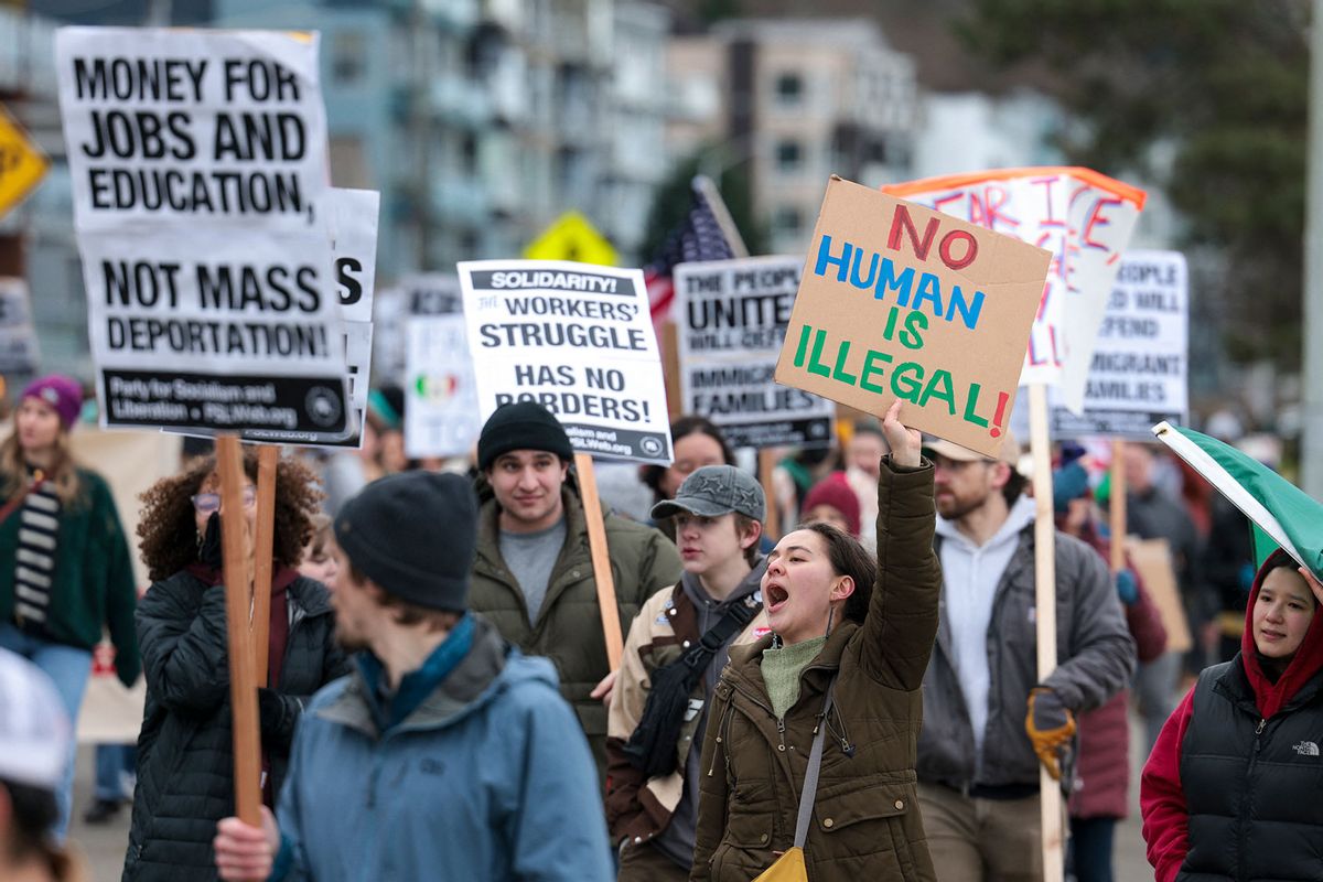People hold signs during a march against Immigration and Customs Enforcement (ICE) entitled "Get our Gente Out of Guantanamo Bay!" in Seattle, Washington, on February 8, 2025. (JASON REDMOND/AFP via Getty Images)