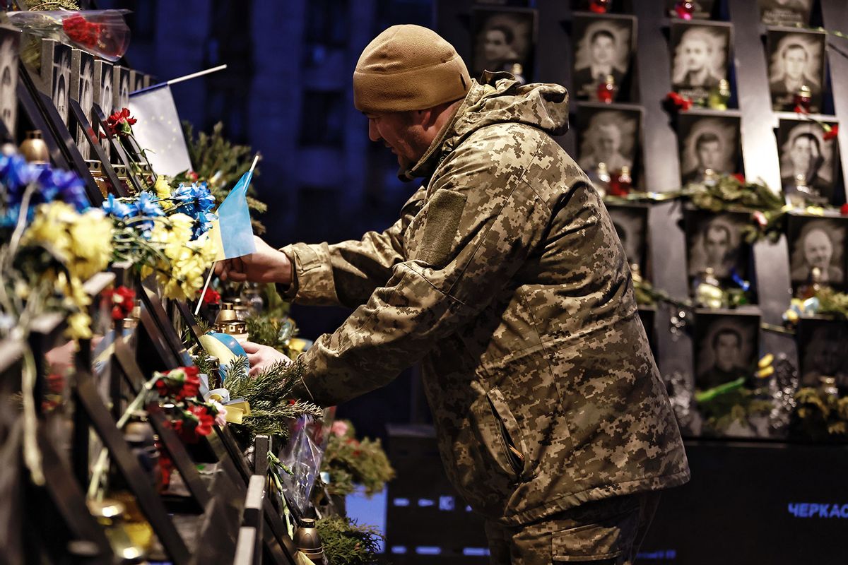 A Ukrainian military member puts Ukrainian flag at the memorial of Heavenly Hundred Heroes, who were killed in 2014 during the mass Euromaidan protest, during commemoration action on February 18, 2025 in Kyiv, Ukraine. (Yan Dobronosov/Global Images Ukraine via Getty Images)
