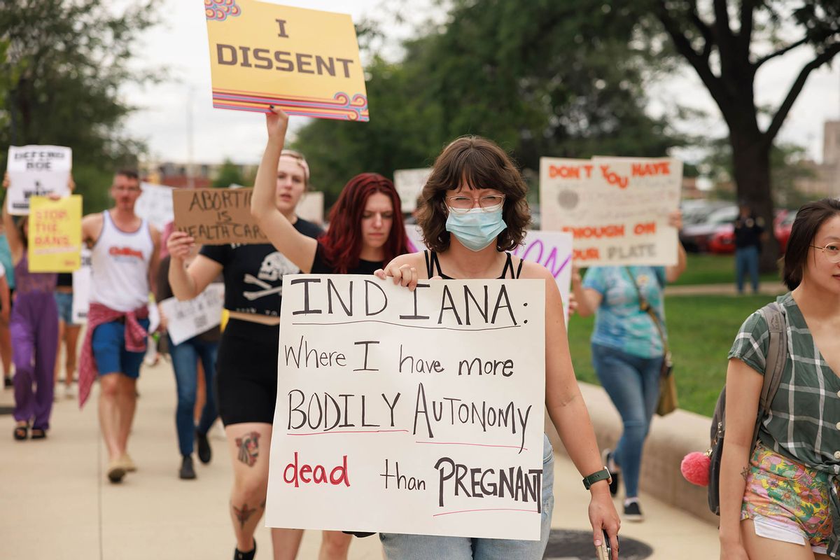 A woman carries a placard saying 'Indiana where I have more bodily autonomy dead than pregnant,' as abortion-rights protesters march around the Indiana State house during the demonstration. (Jeremy Hogan/SOPA Images/LightRocket via Getty Images)