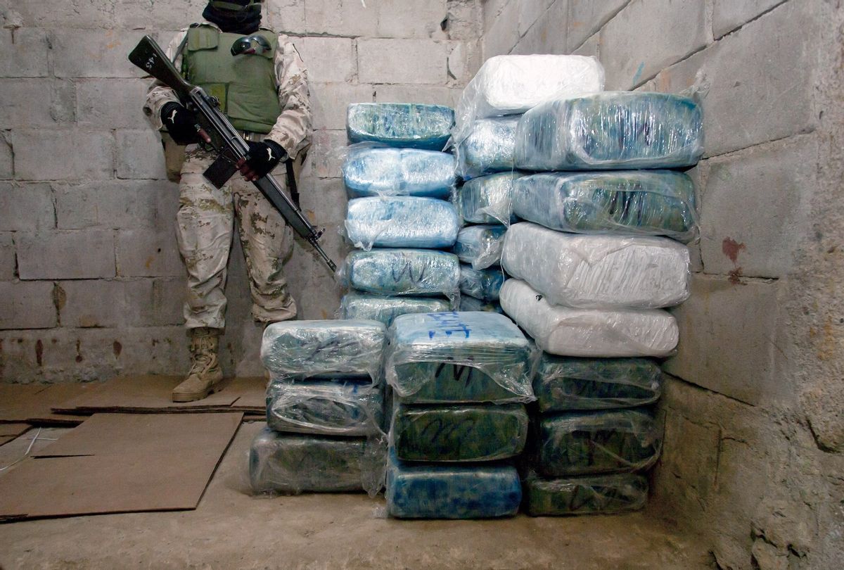 A Mexican soldier stands guard next to marijuana packages outside a tunnel discovered at a warehouse in Tijuana, Baja California state, Mexico, near the border with the US on November 26, 2010.  (FRANCISCO VEGA/AFP via Getty Images)