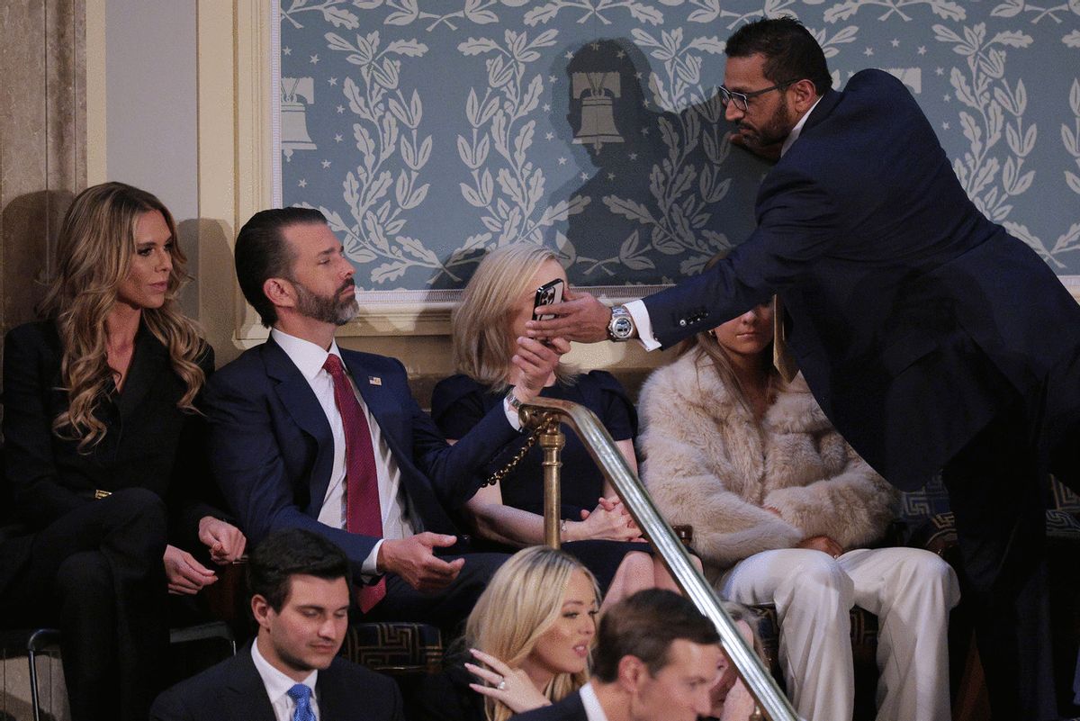 Federal Bureau of Investigation Director Kash Patel (R) shows his phone to Donald Trump Jr. and his girlfriend Bettina Anderson in the House Chamber before U.S. President Donald Trump's address to a joint session of Congress at the U.S. Capitol on March 04, 2025 in Washington, DC. (Chip Somodevilla/Getty Images)