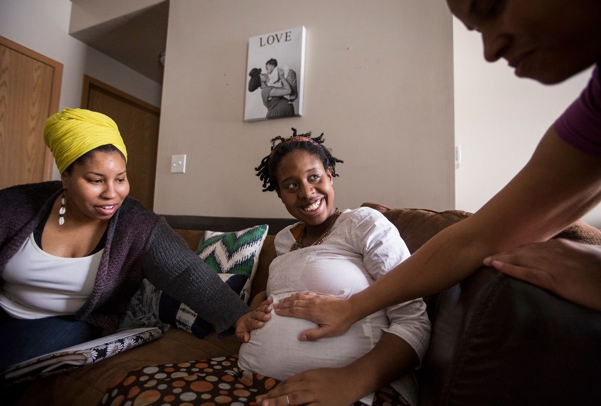 Clara Sharp, left, and Sonja Watley, right, both doulas and co-directors of the company Ahavah Birthworks, visit expectant mother Claire Littleton, center, who is on Medicaid, at her home in north Minneapolis on Wednesday, January 13, 2016. (Photo by Leila Navidi/Star Tribune via Getty Images)