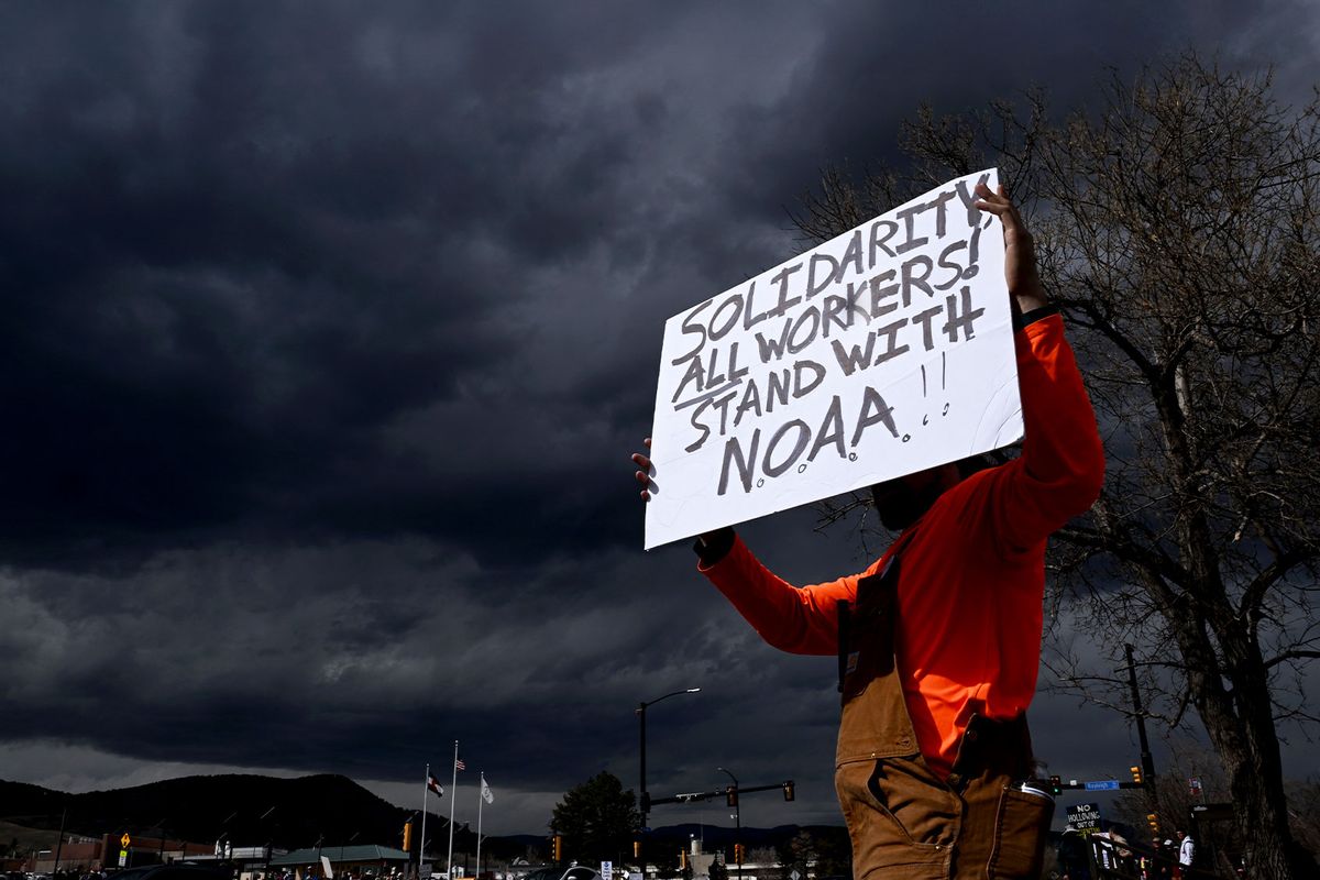 A man who did not want to be identified holds up a sign while standing along Broadway as he joins hundreds of others during a large rally and protest outside of NOAA in Boulder, Colorado on March 3, 2025. (Helen H. Richardson/MediaNews Group/The Denver Post via Getty Images)