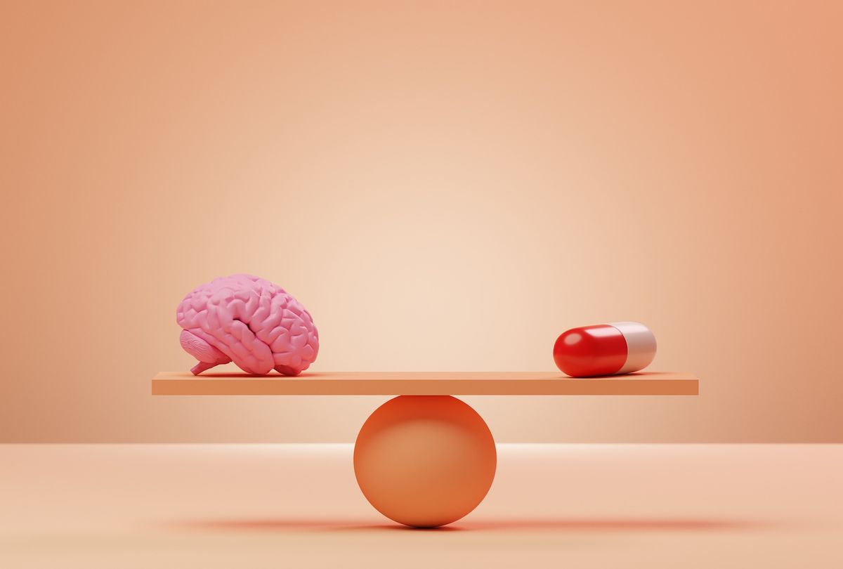 Conceptual image of an orange seesaw with a pink brain and an oversized pill balancing on it. (Getty Images / J Studios)