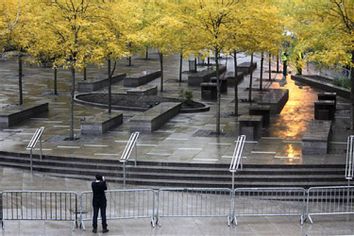 A pedestrian takes a picture of an empty and closed Zuccotti Park in New York, Tuesday, Nov. 15, 2011.