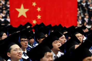 Students attend their college graduation ceremony in Shanghai's Fudan University July 2, 2011.