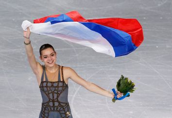 Russia's Adelina Sotnikova celebrates holding her flag at the end of the Figure Skating Women's free skating Program at the Sochi 2014 Winter Olympics