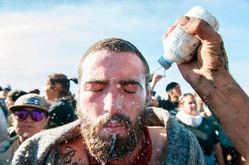 A person pours a pepper spray antidote into a protester's eyes during a protest against the building of a pipeline on the Standing Rock Indian Reservation near Cannonball, North Dakota