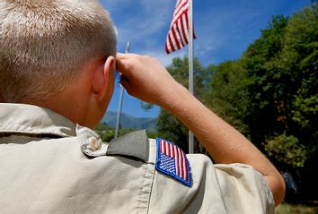 A Boy Scout salutes the American flag.