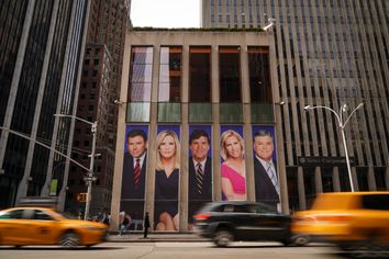 Tucker Carlson and Sean Hannity's images displayed on the side of the Fox News building in midtown Manhattan.