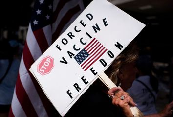 Anti-vaccine rally protesters hold signs