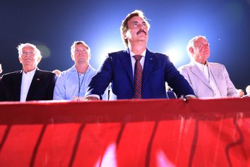 Founder and CEO of My Pillow, conservative political activist and conspiracy theorist Mike Lindell (C) listens to former U.S. President Donald Trump addresses supporters during a 