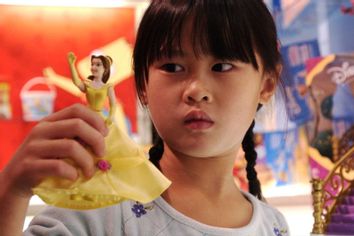 Little girl holding a Disney Princess doll
