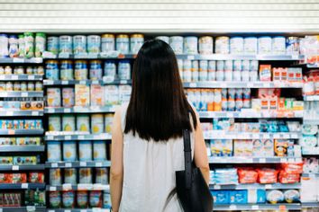 Woman at the grocery store standing in front of products