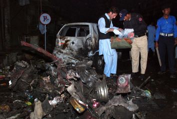 Police officials survey the site of a suicide bomb explosion in Charsadda, located about 20 km (12 miles) northeast of Peshawar