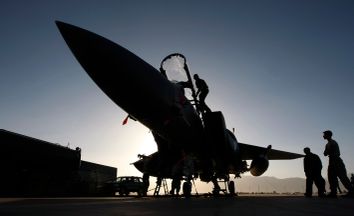 Members of the ground crew work on U.S. Air Force F-15E fighter jet following a mission over Afghanistan at Bagram air base