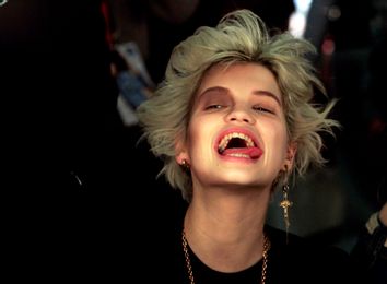 Pixie Geldof, daughter of musician Bob Geldof, reacts while having her make-up applied during London Fashion Week