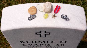 Mementos are placed on a gravestone of USAF Captain Kermit O. Evans Sr. inside Section 60 at Arlington National Cemetery