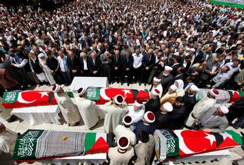 Imams and mourners pray behind the Turkish flag-wrapped coffins of activists, who were killed when Israel seized a Turkish aid ship bound for Gaza, during a funeral ceremony in Istanbul